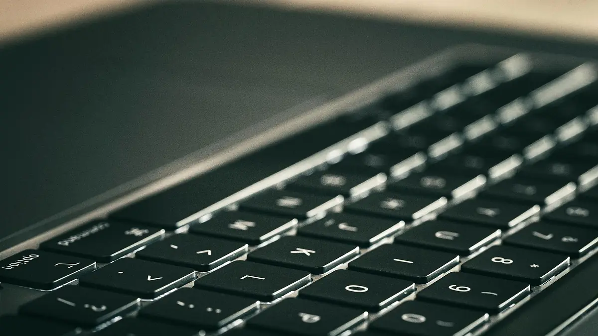 Teclado de una notebook en primer plano, con poca luz