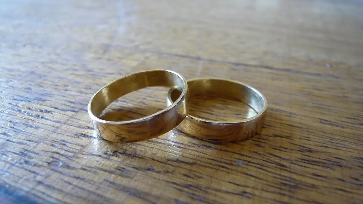 Dos alianzas de oro apoyadas sobre una mesa de madera