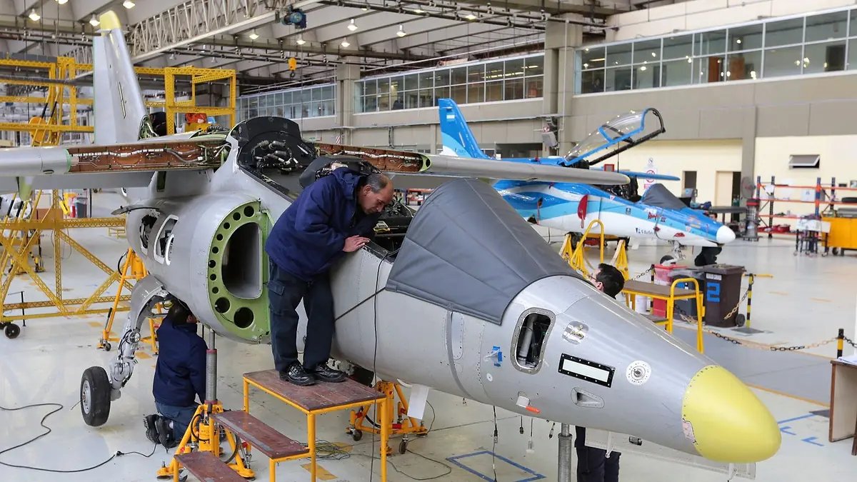 Operarios trabajan sobre el fuselaje de un avión en la planta de FAdeA, en Córdoba