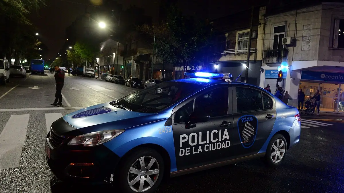 Patrullero de la Policía de la Ciudad de Buenos Aires con las luces encendidas, de noche